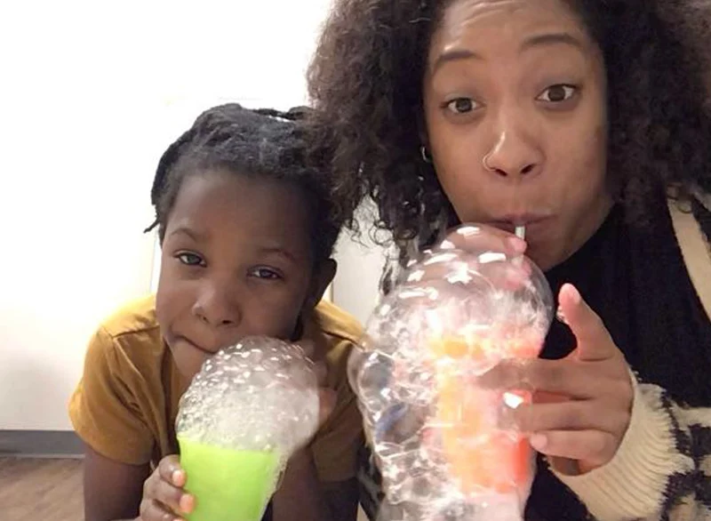 child and therapist blowing bubbles through a straw