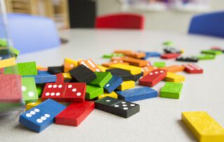 Colorful dominoes scattered on a table at our Blue Bird Day Northcenter Chicago location.