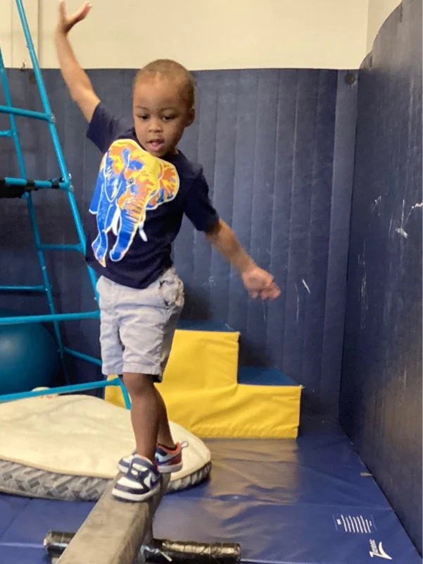 Child walking on balance beam at Blue Bird Day