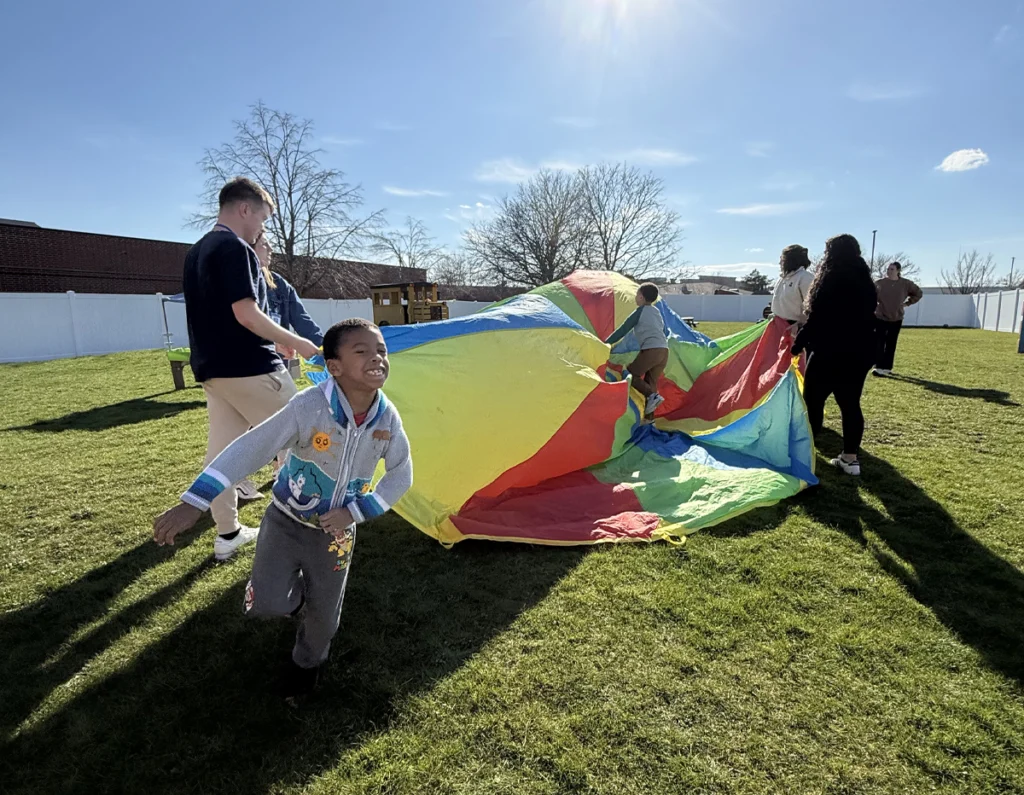 Children and Therapists at Blue Bird Day Outdoors in Wheaton Playing a Parachute Game