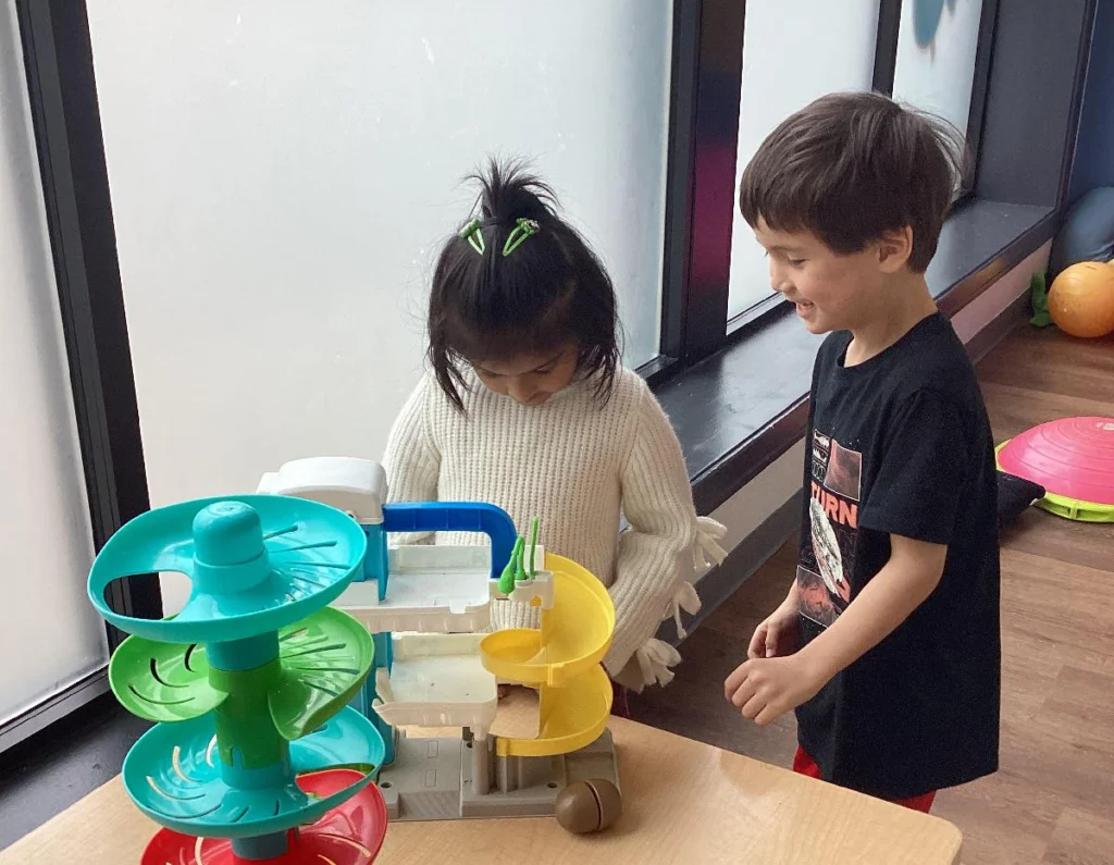 Two Children at Blue Bird Day Playing a Game Together at a Table