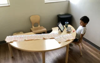 Child at table with alphabet worksheet activity