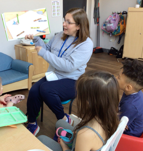 Therapist reading a book to children in circle time at Blue Bird Day northcenter.