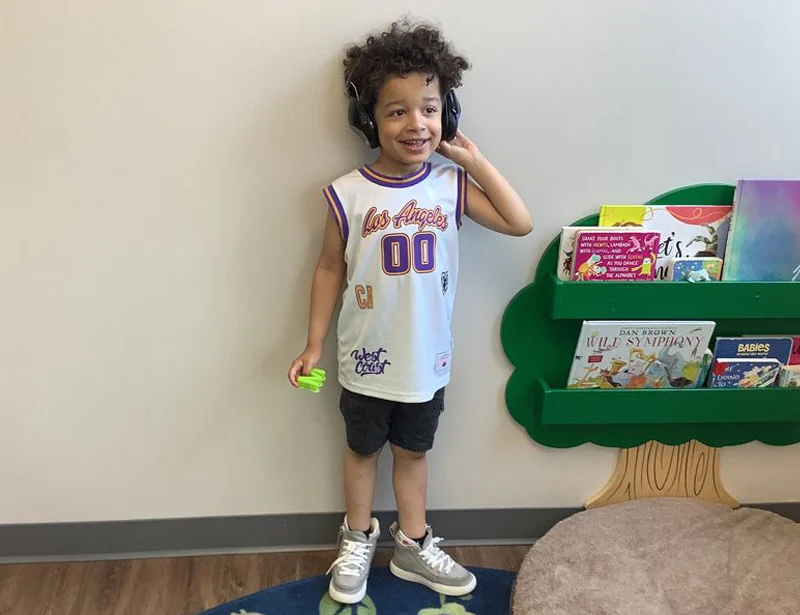 Child wearing noise cancelling headphones in Blue Bird Day classroom