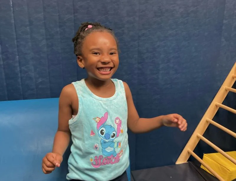 Happy child at Blue Bird Day in therapeutic gym