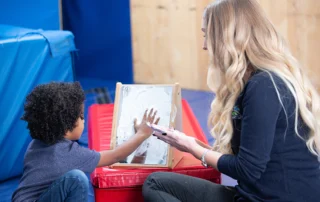 child and therapist sensory play with mirror in therapeutic Blue Bird Day gym